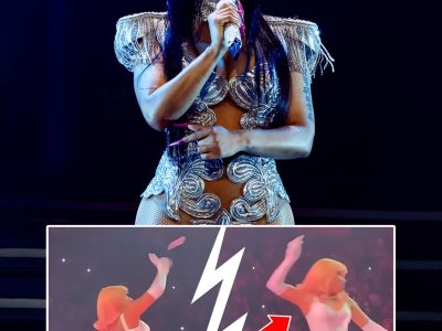 Nicki Minaj throws an object at her back into the crowd.